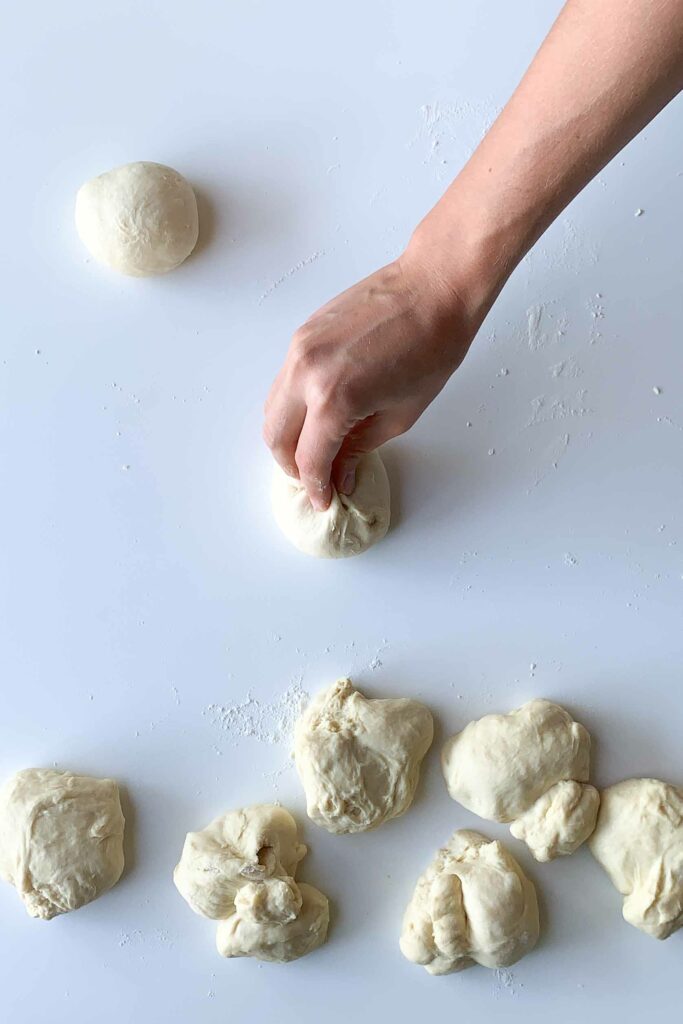 hand pinching bun dough into ball