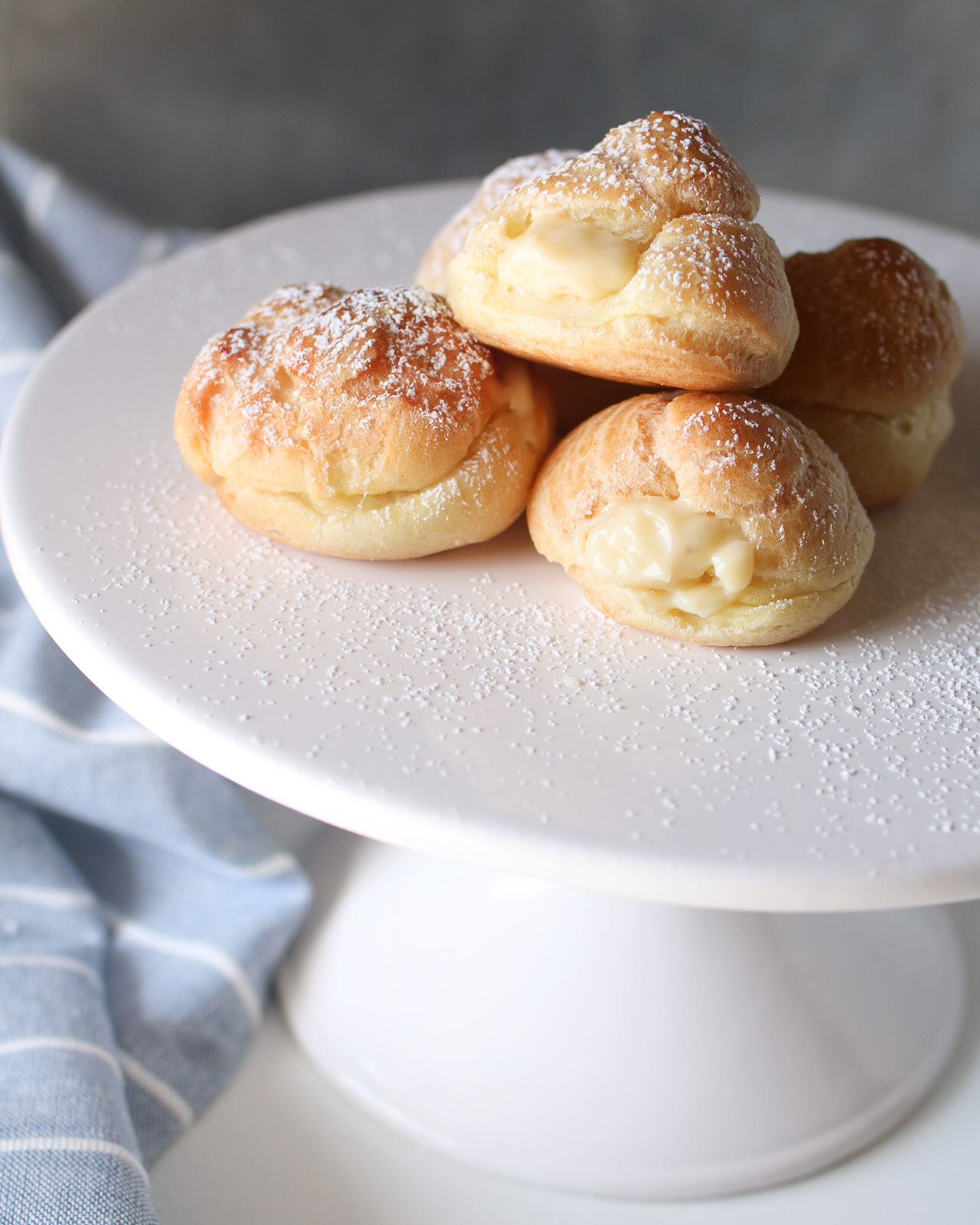 cake stand with stacked homemade cream puffs