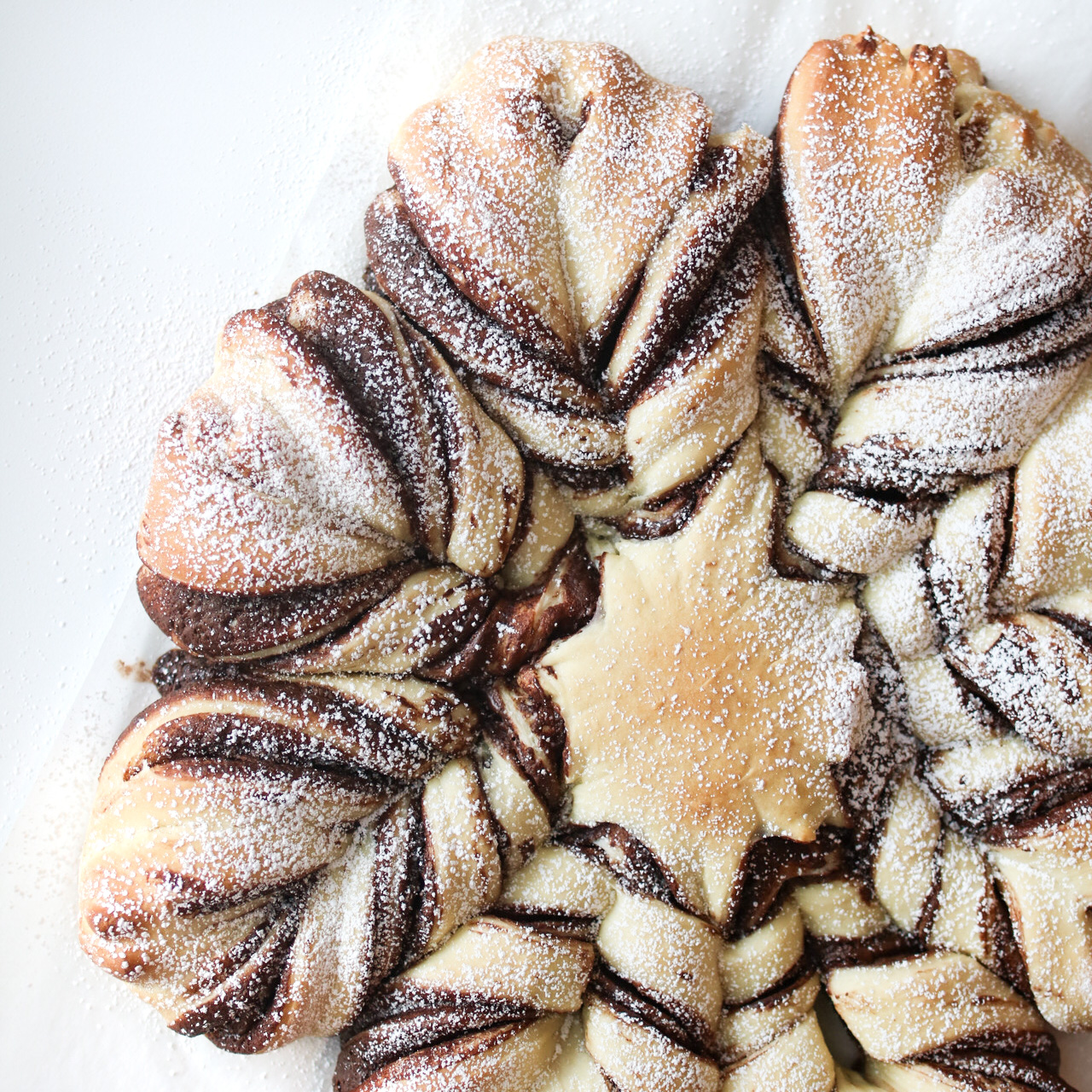 overhead view of a homemade star bread sprinkled with powdered sugar