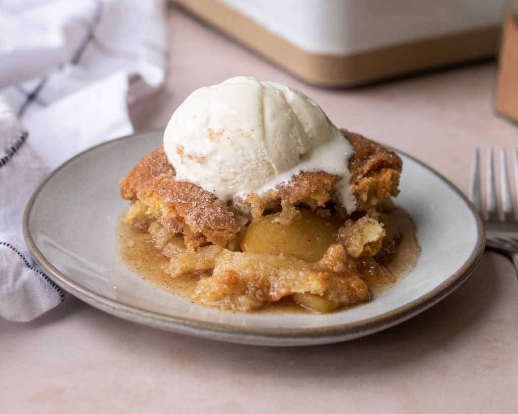 plate of snickerdoodle apple cobbler with scoop of ice cream on top