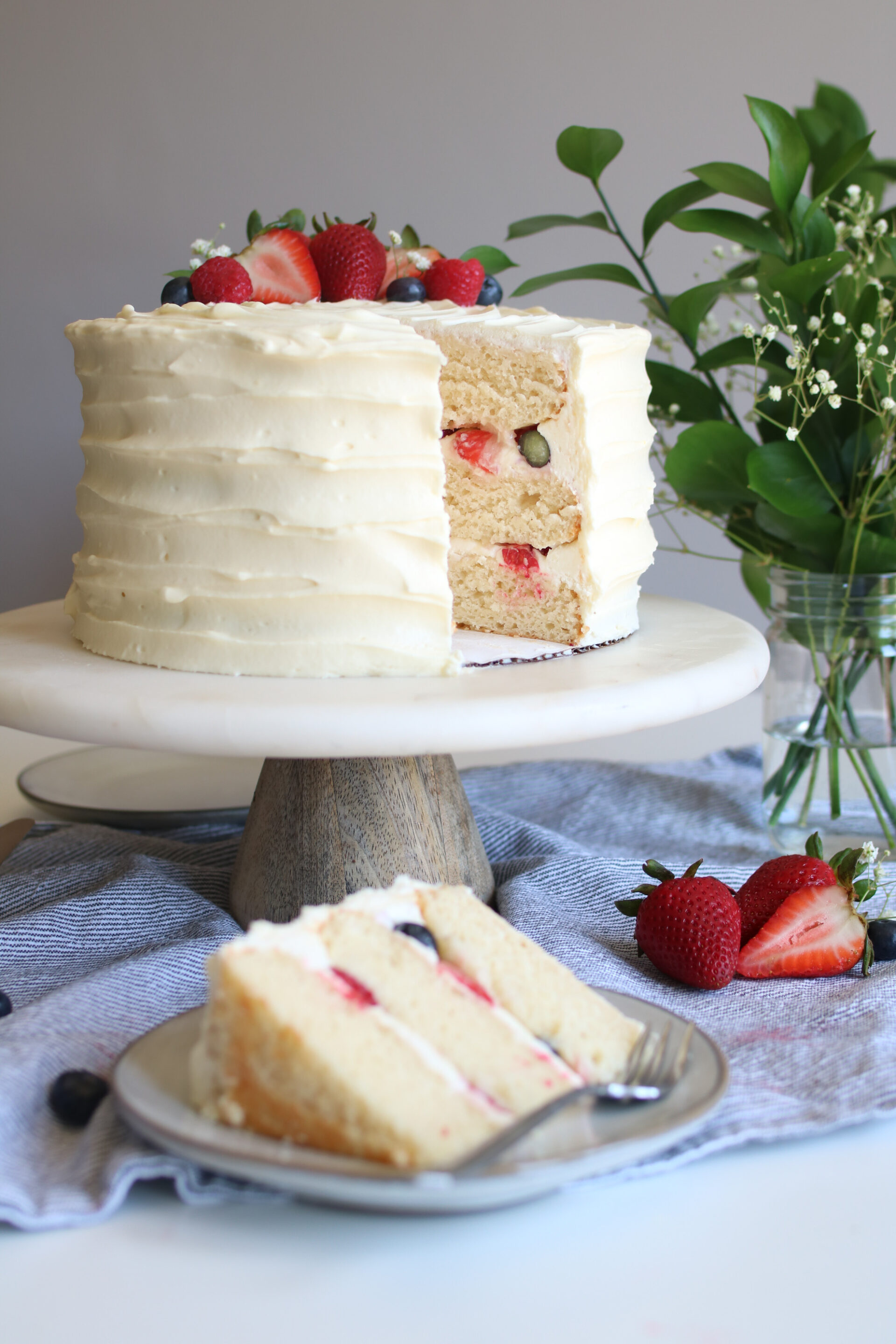 white chocolate berries and cream cake with slice out